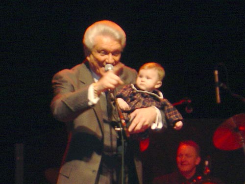 Tommy holding his granddaughter nicole on stage